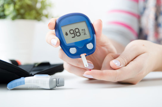 Woman checking blood sugar level by glucometer